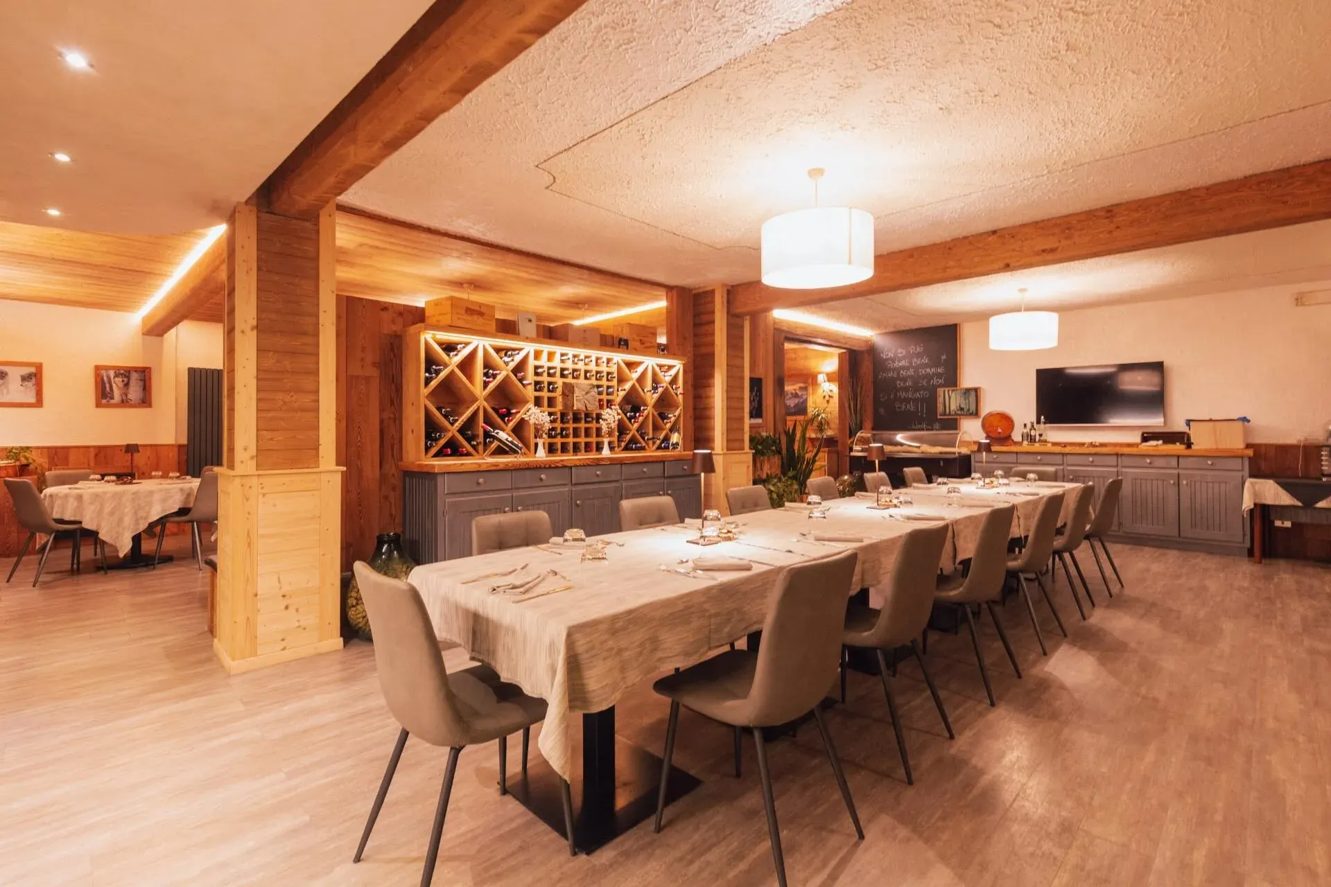 La sala del ristorante Valle Pesio, legno chiaro e tavola apparecchiata